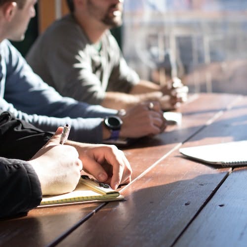 People in a meeting with notebooks>